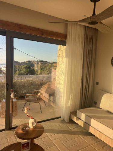 a bedroom with a bed and a balcony with a view at Lithos Luxury Villa in Archangelos