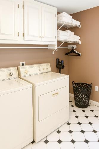 a laundry room with white appliances and a checkered floor at Lawrence RIdge in Adamstown