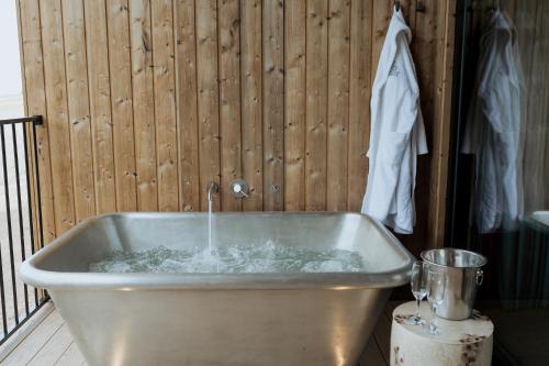 a bath tub with water in it next to a wall at The Tempus at Charlton Hall Estate in Alnwick