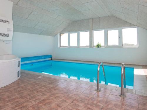 a large swimming pool with blue water in a room at 5 star holiday home in Ringkøbing in Ringkøbing