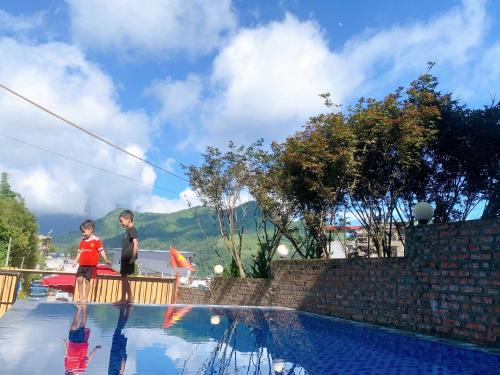 two young boys standing next to a swimming pool at Thanh Truc House in Sa Pa