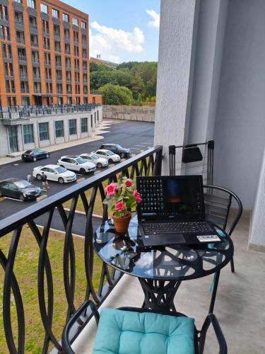 a laptop sitting on a glass table on a balcony at Alvina 2 apartment hotel in Tsaghkadzor