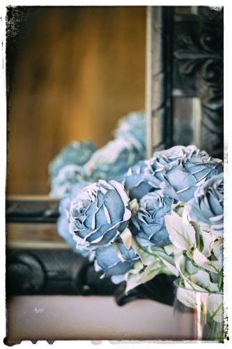 a bouquet of blue and pink flowers in a mirror at The Great Gatsby Houghton in Johannesburg