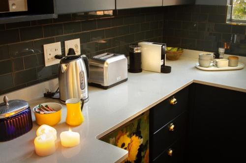 a kitchen counter with a toaster and some candles at The Great Gatsby Houghton in Johannesburg