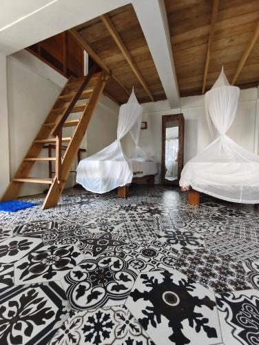 a room with two beds and a staircase at Casa Nemo Beach Resort & Spa in Sabong