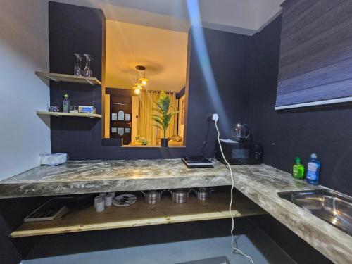 eine Küche mit einer Theke mit einem Waschbecken und einem Spiegel in der Unterkunft Fly Africa village 3 in Arusha
