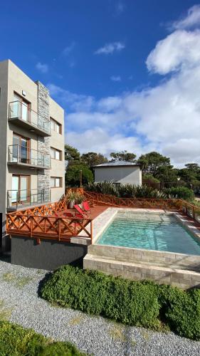 a building with a swimming pool next to a building at Cepas de Mar Resort & Wine in Las Gaviotas