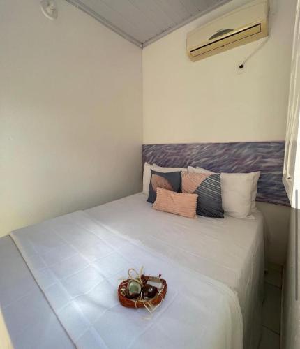 a room with a bed with a basket on it at Casinha Azul in Ilha de Boipeba