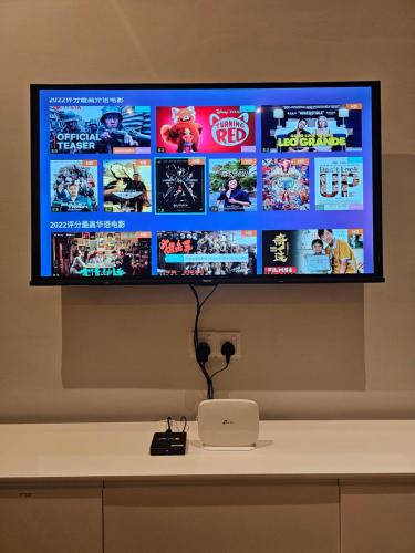 a flat screen tv on a wall with a laptop at NEW Bangsar Trade Centre KL Mid Valley LRT Bangsar in Kuala Lumpur