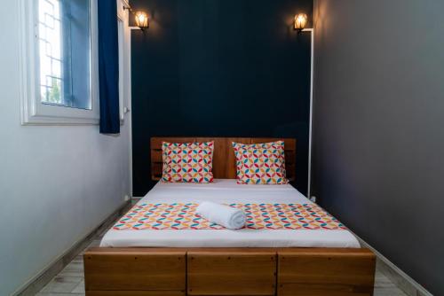 a small bed in a room with a blue wall at Cattleya Guest house in Hell-Ville