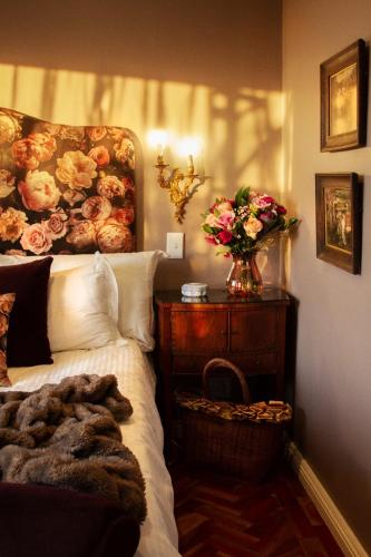 a bedroom with a bed and a vase of flowers at The Great Gatsby Houghton in Johannesburg