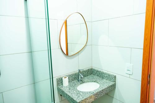 a bathroom with a sink and a mirror at Pousada Passarada - Tudo novinho te esperando in Pirenópolis