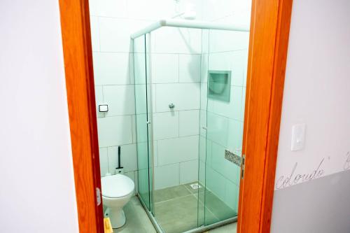 a glass shower in a bathroom with a toilet at Pousada Passarada - Tudo novinho te esperando in Pirenópolis