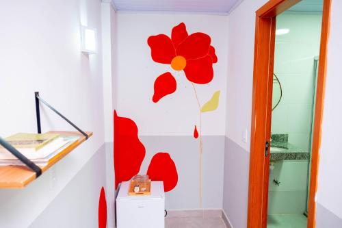 a bathroom with a red flower on the wall at Pousada Passarada - Tudo novinho te esperando in Pirenópolis