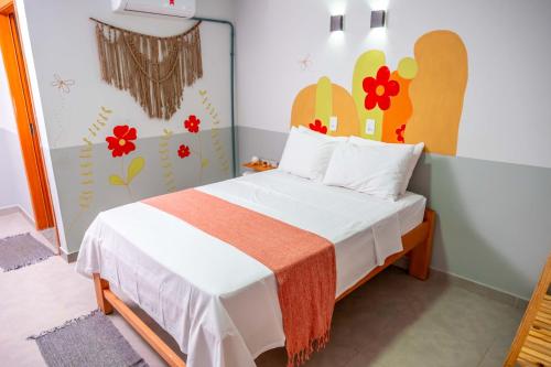 a bedroom with a bed with a flower mural on the wall at Pousada Passarada - Tudo novinho te esperando in Pirenópolis