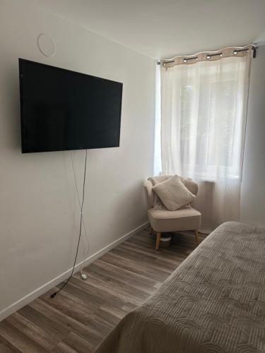 a bedroom with a tv on the wall and a chair at Pause Campagne 1 