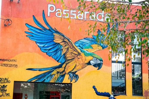 a painting of a parrot on the side of a building at Pousada Passarada - Tudo novinho te esperando in Pirenópolis