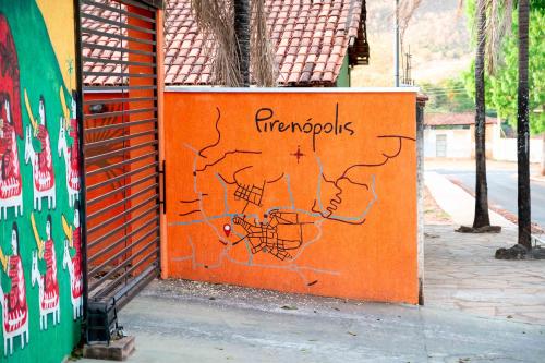 an orange wall with a drawing of a map on it at Pousada Passarada - Tudo novinho te esperando in Pirenópolis