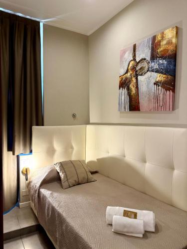 a bedroom with a large bed with a painting on the wall at Carlo Goldoni Hotel in Milan