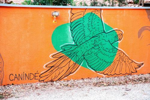 a painting of a peacock on the side of a wall at Pousada Passarada - Tudo novinho te esperando in Pirenópolis