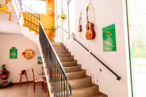 a staircase in a house with a guitar on the wall at Pousada Passarada - Tudo novinho te esperando in Pirenópolis