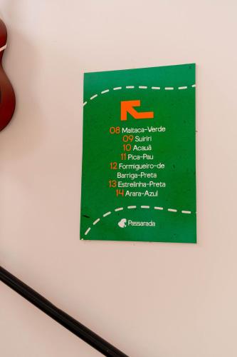 a sign is hanging on a wall at Pousada Passarada - Tudo novinho te esperando in Pirenópolis