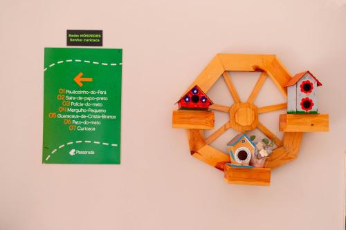 a wooden toy house and a sign on a wall at Pousada Passarada - Tudo novinho te esperando in Pirenópolis