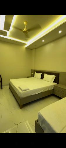 a bedroom with two beds and a ceiling at Hotel Shree Ganga Palace in Gwalior