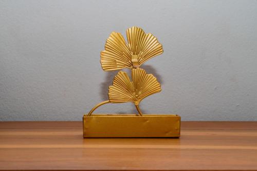a metal plant in a yellow box on a table at Cattleya Guest house in Hell-Ville
