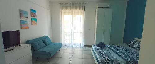 a room with a bed and a chair and a television at Perla blu Salento in Gallipoli