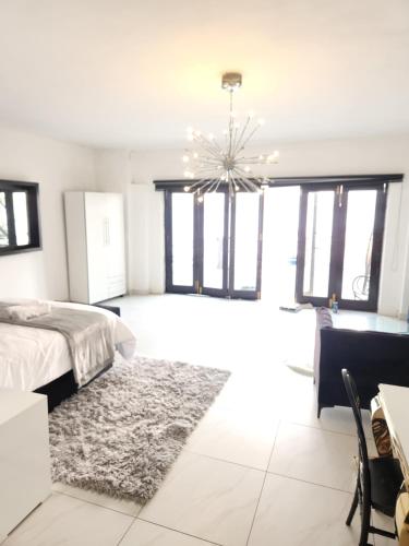 a bedroom with a bed and a chandelier at Le Bamboo Guest House And Boat Cruise in Hartbeespoort