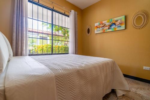 a bedroom with a white bed and a window at Fun! Great Location-near Beaches-shopping-medical in Parrita
