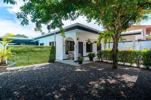 a white house with a tree in front of it at Fun! Great Location-near Beaches-shopping-medical in Parrita