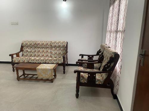a living room with two chairs and a couch at Peacock Residence in Dickwella
