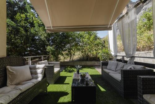 an outdoor patio with wicker furniture and a table at Villa Under Meteora in Kalabaka