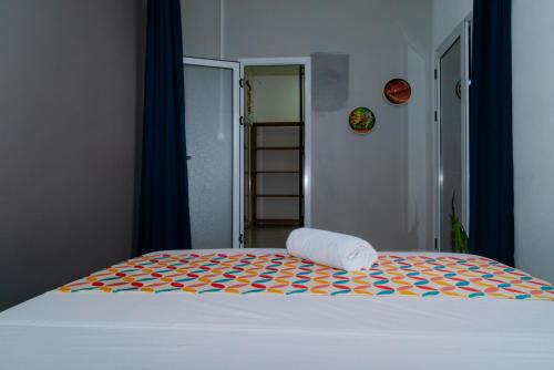a bed with a towel sitting on top of it at Cattleya Guest house in Hell-Ville