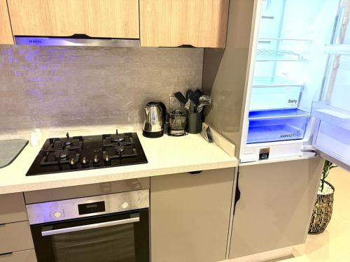 a kitchen with a stove top oven next to a window at Luxury Apartment with Pool & Parking in Tamraght 10 mn from Taghazout in Tamraght Ouzdar