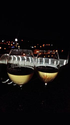two glasses of wine sitting next to each other at Apartman Centar in Teslić
