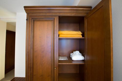 a wooden closet with yellow towels in a room at Burghotel Nürnberg in Nürnberg