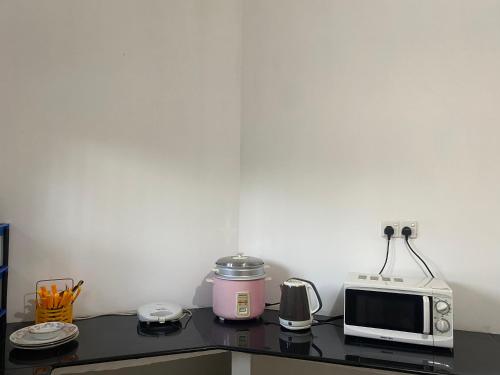 a kitchen counter with a microwave and a toaster at Peacock Residence in Dickwella