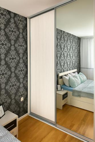 a bedroom with a bed and a sliding glass door at Apartman Bloom in Sarajevo