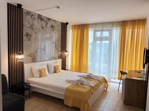 キテンにあるHotel Onyxのベッドルーム1室(黄色のカーテン付きの大型ベッド1台付)