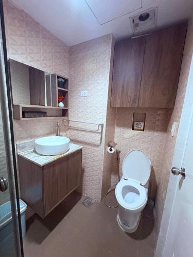 a small bathroom with a toilet and a sink at Sunvida Tower Corner Suite Across SM Cebu in Cebu City