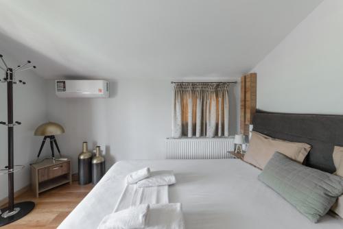 une chambre avec un grand lit blanc et une fenêtre dans l'établissement Kalliston - Meteora, à Kalambaka