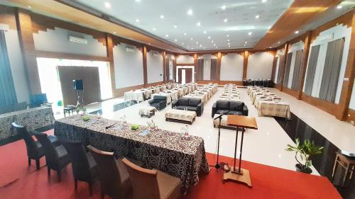 a large banquet hall with a long table and chairs at Montana Hotel Kuningan in Panawuan
