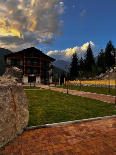 a building with a large rock in front of it at Kakhri Resort in Mestia