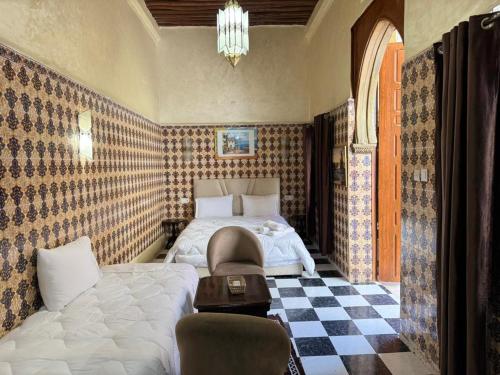 a bedroom with a bed and a checkered floor at Riad Shama in Rabat