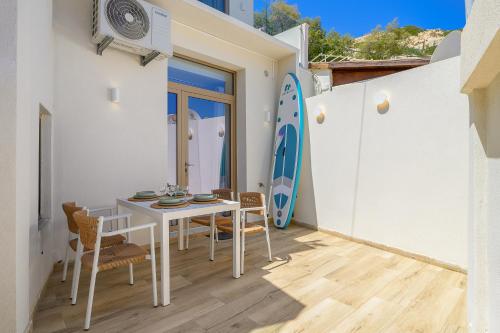 a dining room with a table and chairs and a surfboard at La SABBIA 3 in Matala