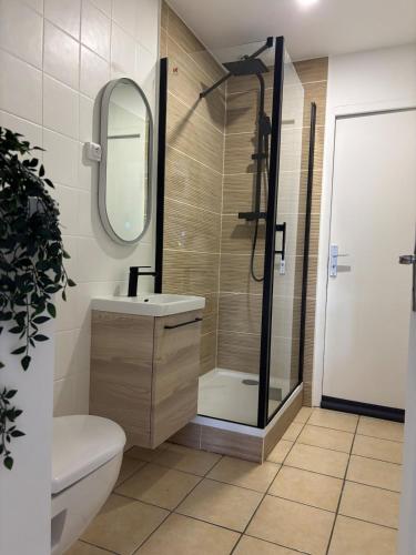 Un baño con ducha, lavabo y espejo. en L'Escapade, en La Celle-sous-Gouzon