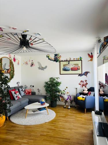 a living room with a couch and a table at THE ENCHANTED HOUSE ( 15 min walk to Disney) in Serris